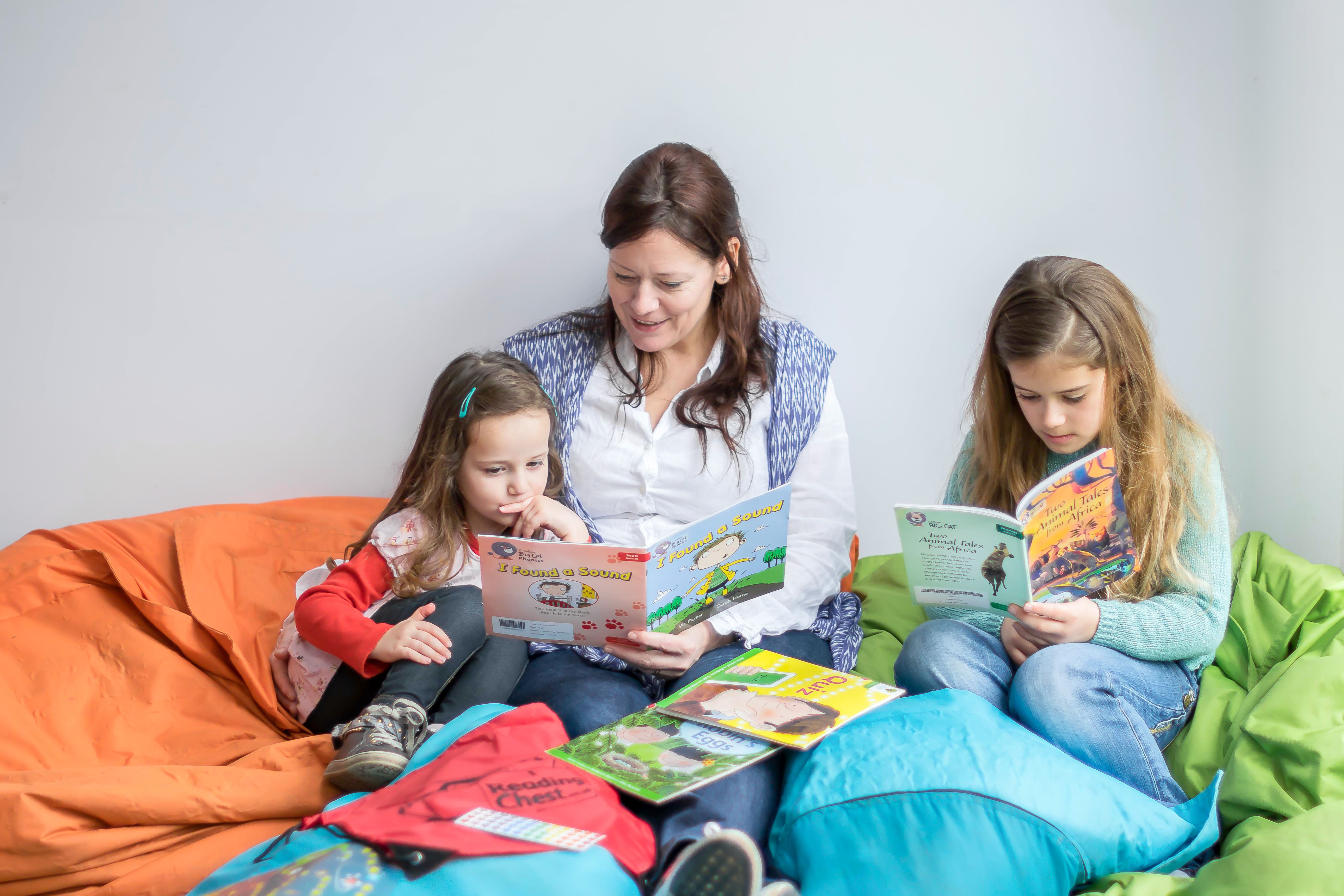 three children reading books together